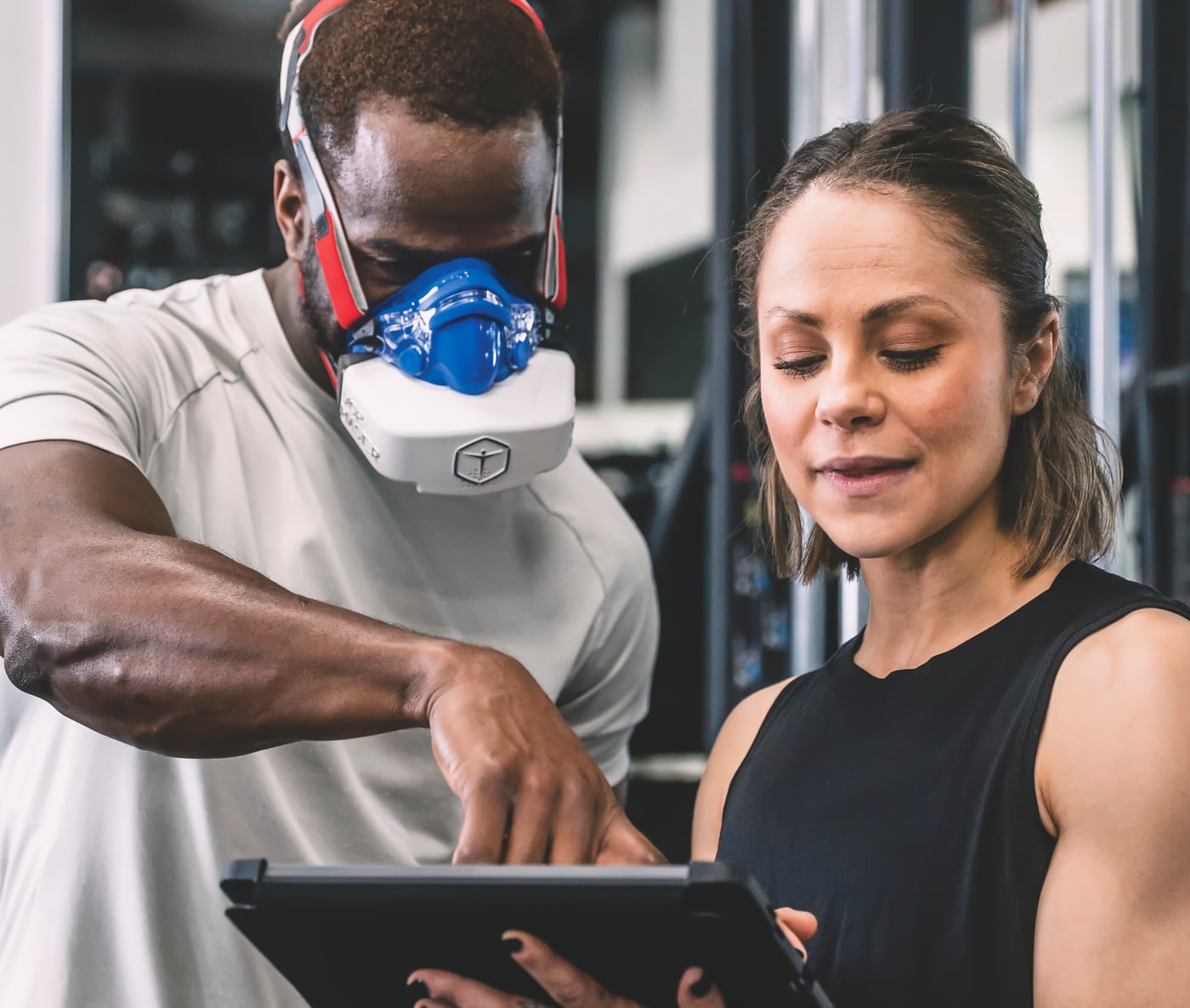 Athlete wearing a VO2 mask while a coach reviews training data